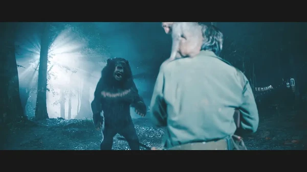 A character in Móng Vuốt confronts a menacing monster in a dim - lit forest scene.