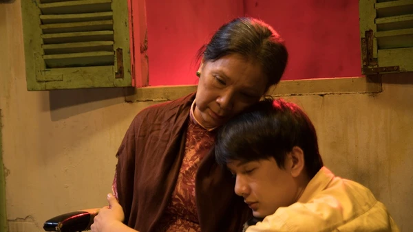 In "Có căn nhà nằm nghe nắng mưa", a mother and son share a tender hug.