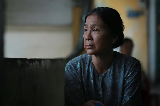 "Có căn nhà nằm nghe nắng mưa" shows a woman lost in thought, gazing into the distance.